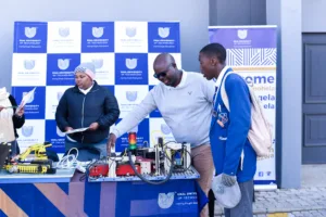 Grade 12 learners engaging with university representatives at a career exhibition booth.