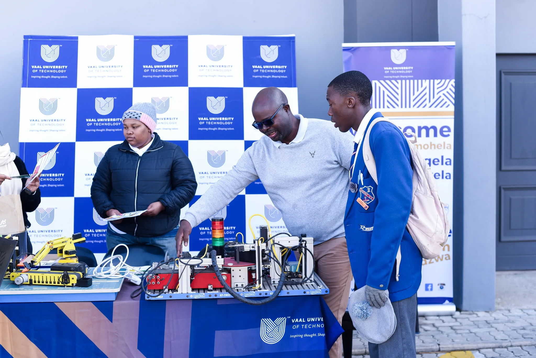 Grade 12 learners engaging with university representatives at a career exhibition booth.