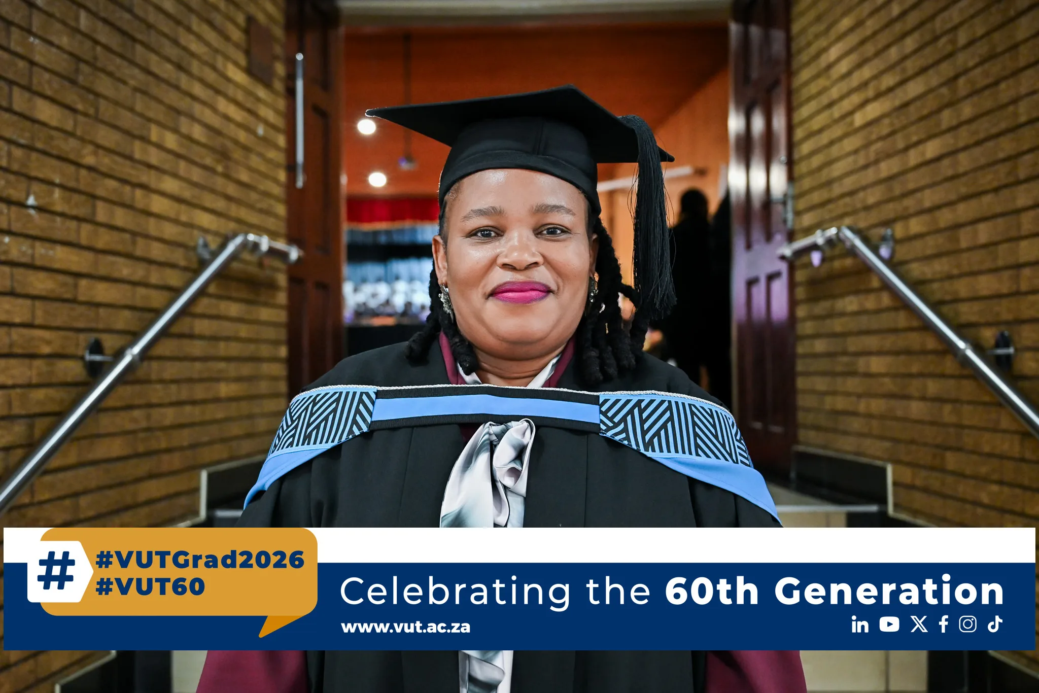 Ms Mosese – Vaal University of Technology Graduate in mortarboard and gown smiles at the camera in a brick-walled hallway; banner shows graduation hashtags (#VUTGrad2026, #VUT60).