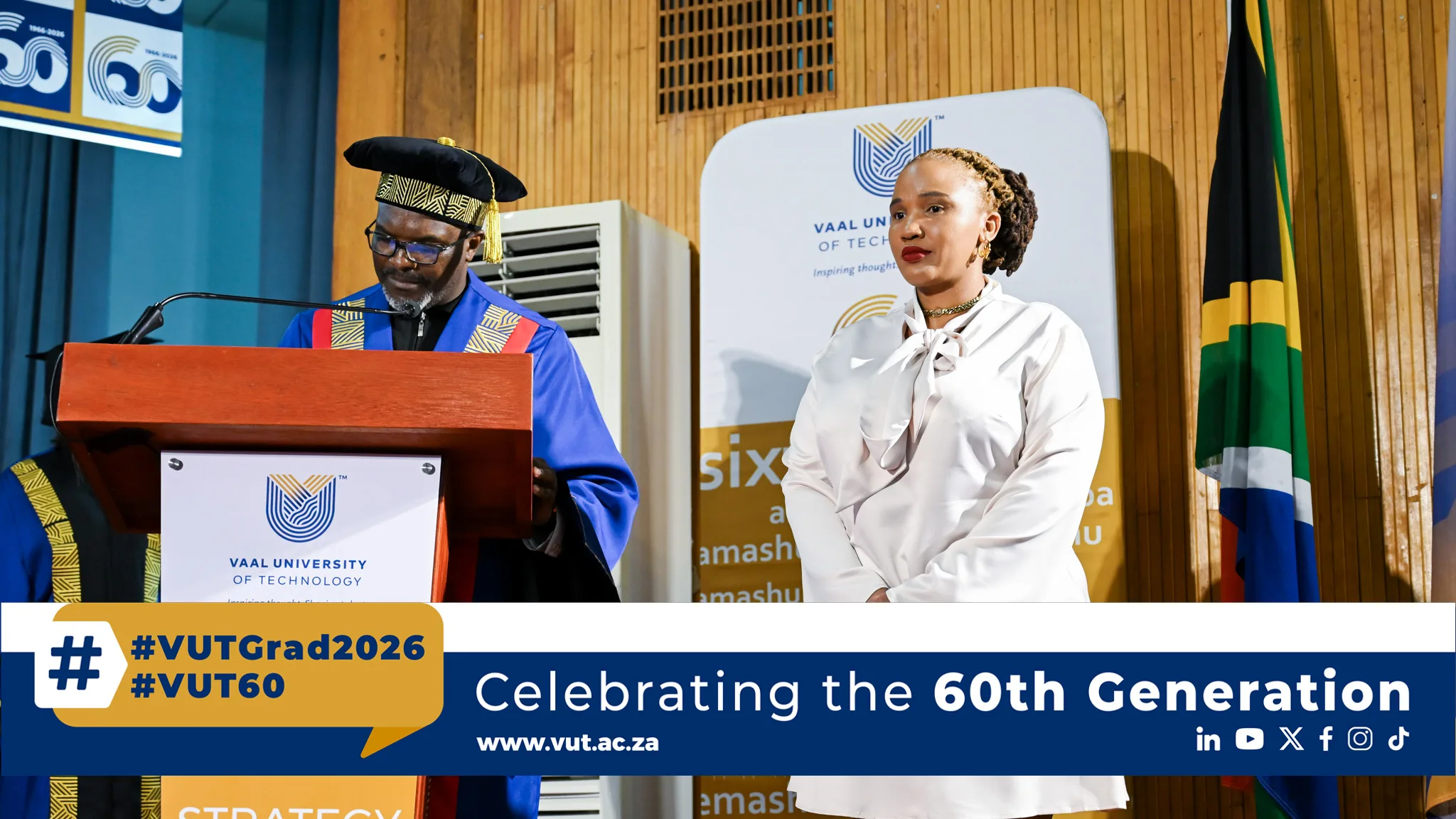 Graduation scene at Vaal University of Technology: a man in an academic blue gown and cap speaks at a podium while a woman in a white blouse stands nearby; banner reads 'Celebrating the 60th Generation'.] }}{