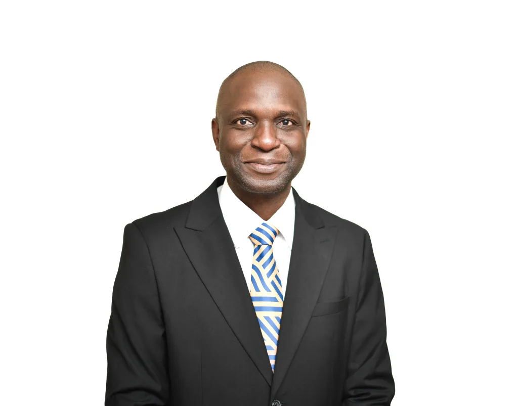 Professional head-and-shoulders portrait of a smiling man in a black suit and striped blue-yellow tie on white background.
