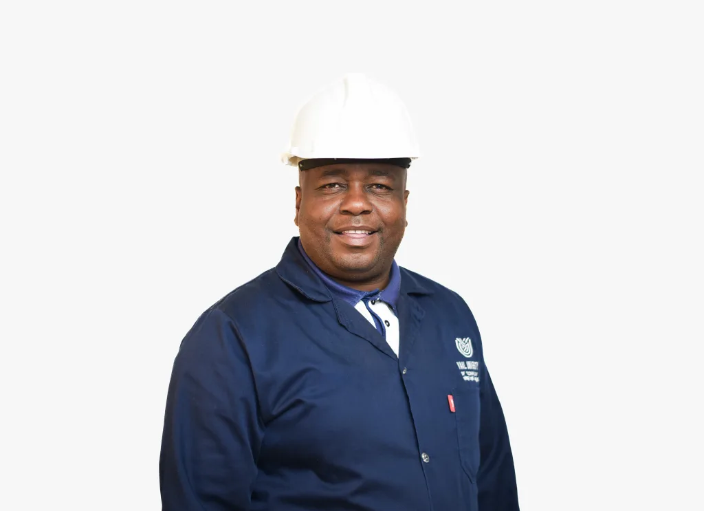 Smiling man in a white safety helmet and navy work uniform against a white background.