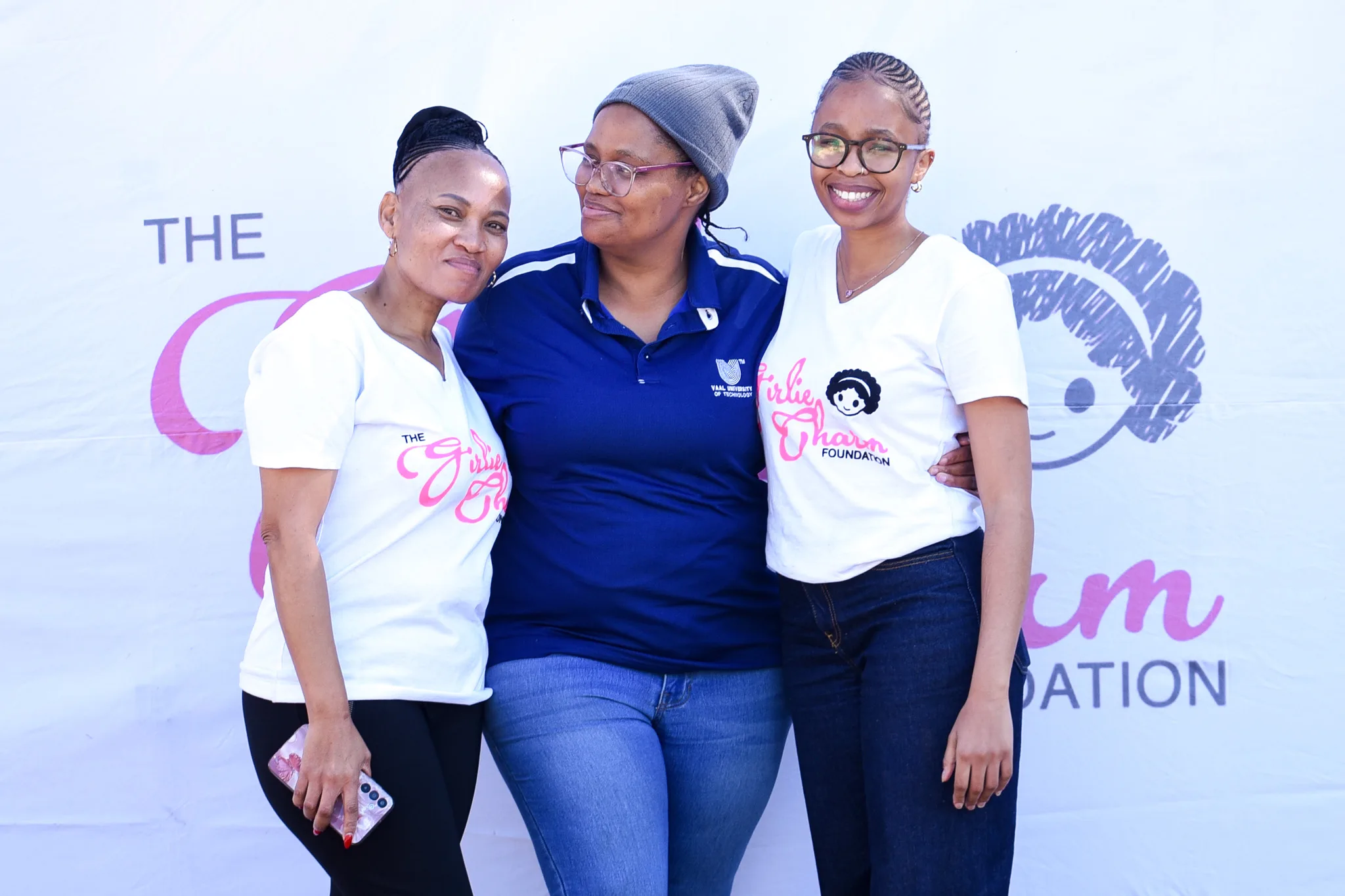 A VUT Community Engagement Department representative (centre) with Girlie Charm representatives.