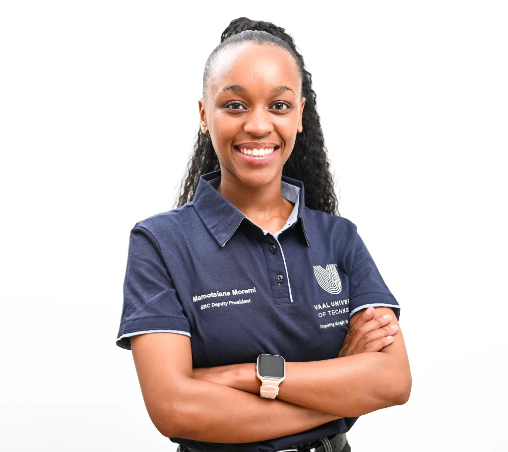 Smiling woman with braided hair, wearing a navy polo shirt and a pink smartwatch on her wrist, against a white background.